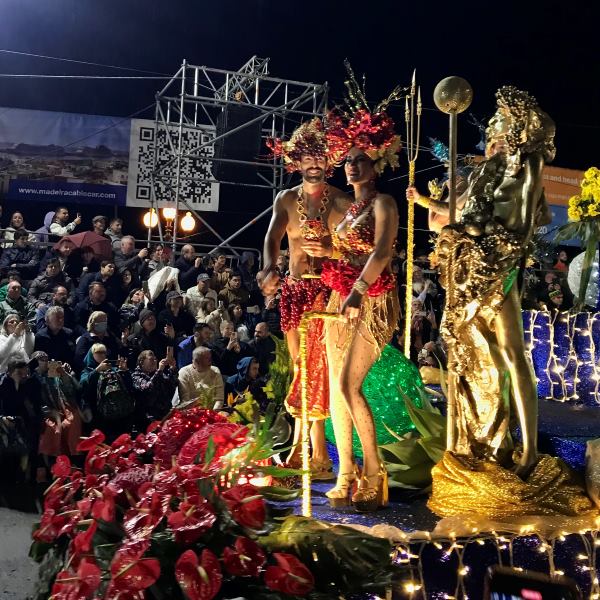 Aranyszínű jelmezes táncosok virágos kocsin a funchali karneválon, Madeira