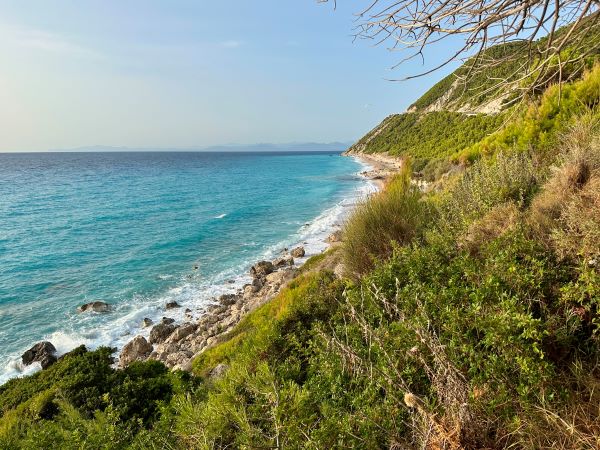 Zöld domboldal és kék öböl a Deck beachside cafe közelében, Lefkáda